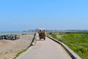 Photo sur Plexiglas Plage de Camps Bay, Le Cap, Afrique du Sud Four wheel bike takes holiday makers to the beach huts on the promenade linking Minnis Bay to Reculver abbey The route is used by cyclists walkers bird watchers and is part of the Viking coastal trail