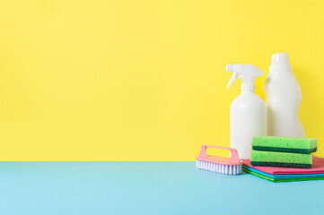 House cleaning products on yellow blue background, copy space. Cleaning service or housekeeping concept with space for text or design