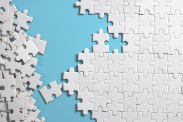 plain blue background with disassemble incomplete white jigsaw puzzle for your background or your content.