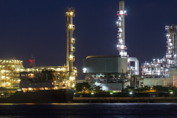 Naklejka premium Oil refinery river side with boat supply tank