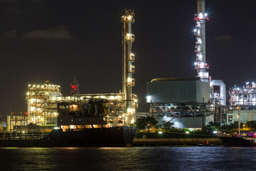 Fototapeta na wymiar Oil refinery on water side front at night