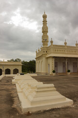 Fototapeta na wymiar A magnificent picture of a few tombs and an Islam mosque minarets of Muslim rulers against the cloudy sky in Karnataka state, in India.