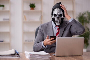 Devil businessman employee sitting at workplace