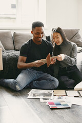 Diverse couple choosing design for new flat