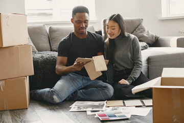 Diverse couple choosing design for new flat