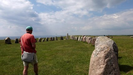 Ales Stenar, Sweden A tourist walking amidst the  1000 year old rock formation shaped like a ship in southern Sweden.