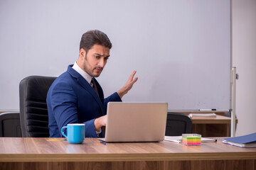 Young handsome employer in teleconference concept