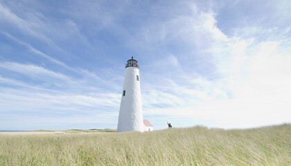 Woman waving from dunes by Great Point Lighthouse, Nantucket Island