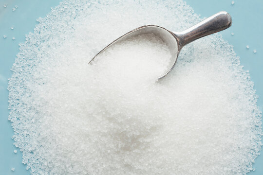 Studio shot of heap of sugar and scoop