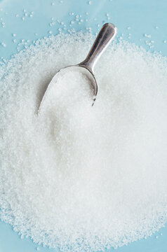 Studio shot of heap of sugar and scoop