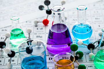 Molecular models and laboratory glassware with liquids on periodic table