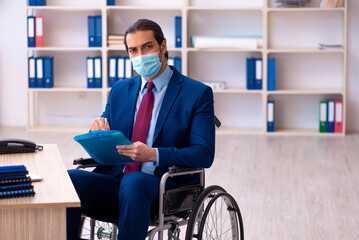 Young disabled employee during pandemic at workplace