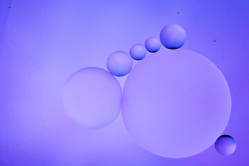 translucent oily liquid bubbles on the water surface, oil drops on the water surface