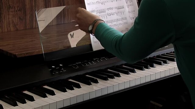 Hands of a Young Woman playing the Electronic Piano. Close Up. 