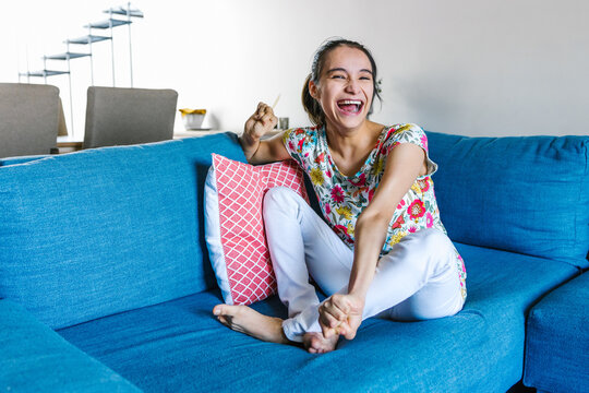 mexican disabled teen girl with cerebral palsy sitting on the couch at home in disability concept in Latin America