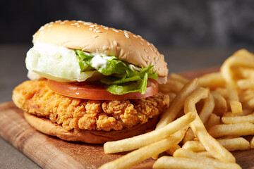 Hamburger and french fries on a wooden chopping board 