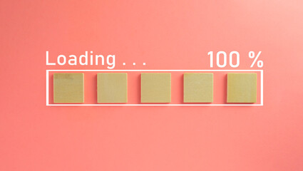 wooden cube with loading 100% progress bar over pink pastel background with copyspace and minimal style use for screen,background concept.