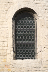 Close-up of window of old protestant roman church at the old town of Payerne at summertime. Photo taken June 11th, 2021, Payerne, Switzerland.