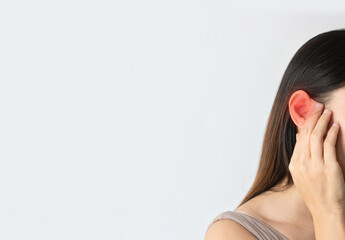Obraz premium Young Asian woman has a sore ear, touching her inflamed ears. Girl suffering from otitis over white background. Free space, closeup