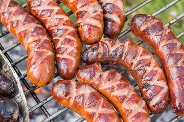 Grilled sausages on the steel grate. Outdoor grilling, garden barbecue (bbq)