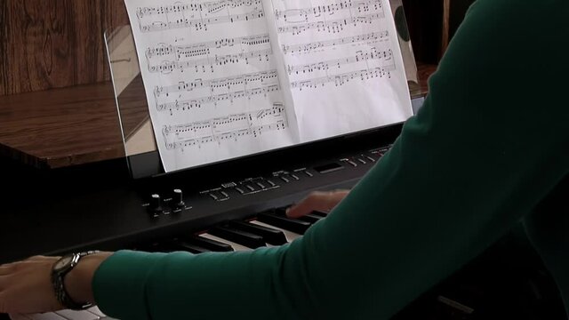 Hands of a Young Woman playing the Electric Piano. Close Up. 