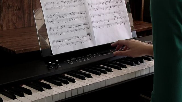 Hands of a Young Woman playing the Electronic Piano. Close Up. 
