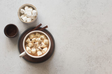 Cup of coffee and white marsmallows on gray stone background