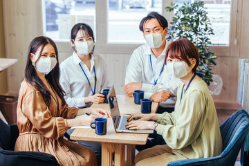 マスクをして打ち合わせする男女

