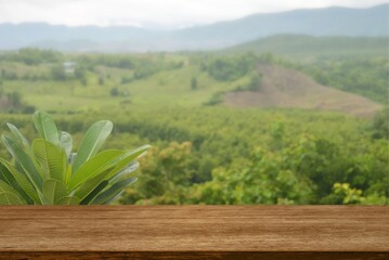 Empty wooden table in front of landscape blurred background