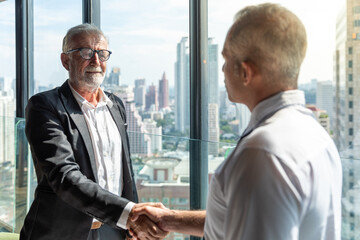 Two business men discussing their business together in a lobby of a hotel. They both wearing white...