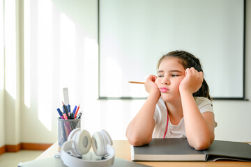 girl student Sitting in the classroom feeling bored with online learning. don't like online education A young female student is sad and tired of not going to school with her friends.