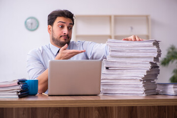 Young businessman employee unhappy with excessive work in the office