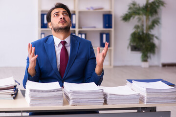 Young businessman employee and too much work in the office