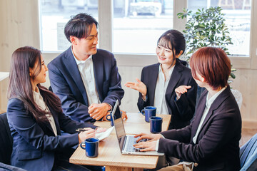カフェ・オフィスで会議する会社員
