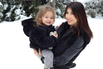 mother and daughter posing on the snow. winter portrait