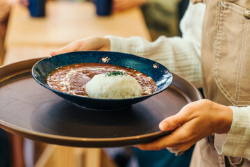 カレーライスを運ぶホールスタッフ