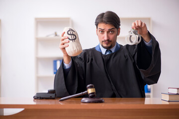 Young male judge working in the courtroom