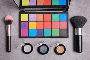 Makeup palette top view with brushes and lipstick