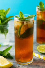 Iced tea with lemon, lime summer cold fruit drink with mint leaves.