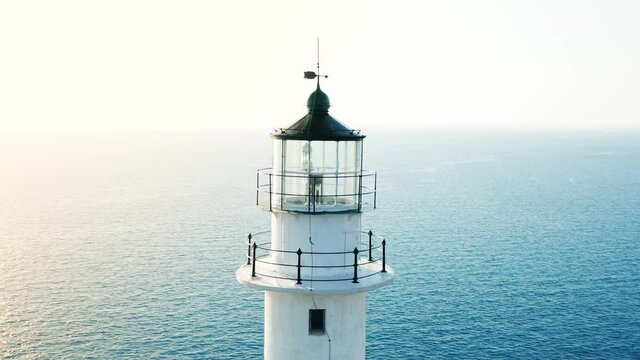 Aerial zoom out reveal shot of Cape of Ducato, white lighthouse of island Lefkada.
