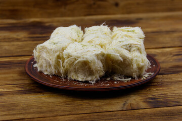 Traditional Turkish dessert Pismaniye with pistachios on wooden table