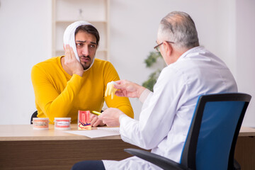 Fototapeta premium Young man visiting experienced male dentist