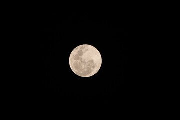 Clear full moon over a dark black background