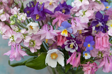 Background with a bouquet of spring and summer bright pink, white and purple flowers, levkoy, matthiola, anemone, pansies. Close-up, blur, postcard.