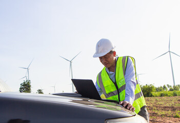 rear view man engineer wearing Personal protective equipment working in wind turbine farm background copy space