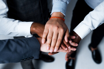Close up photo. The hands of partners and friends are folded on top of each other as a sign of support. Multicultural group