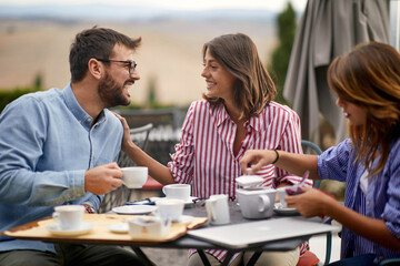 Three friends drinking coffee together