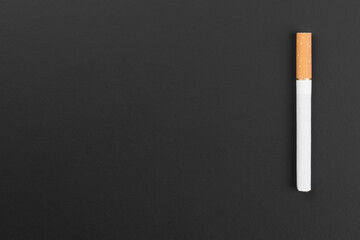 Cigarette with filter on black background. Concept of the problem of illness from smoking cigarettes.