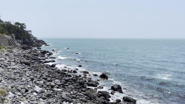 Waves crashing against a reef in the blue sea.