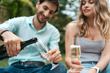 Summer holidays, people, romance, dating concept, couple drinking sparkling wine while enjoying...